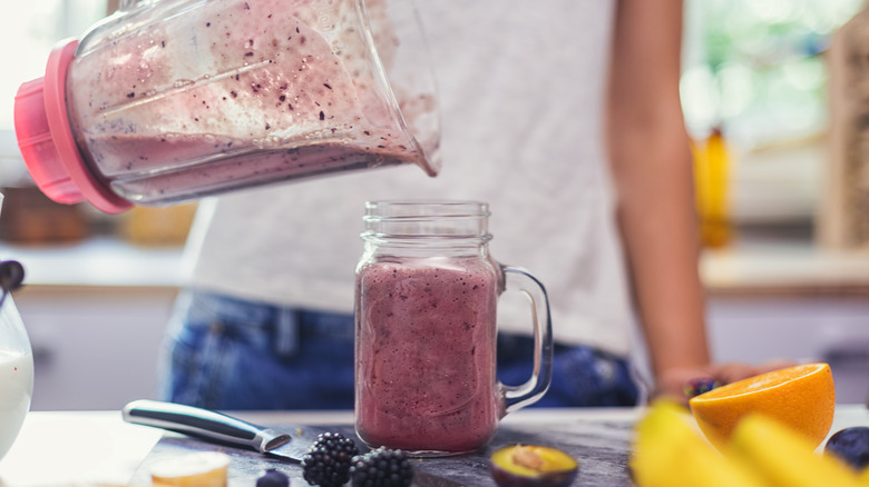 blueberry smoothie pouring into jar