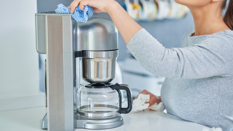 Woman cleaning coffee machine