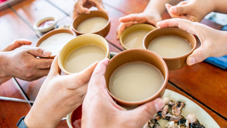 People drink bowls of makgeolli