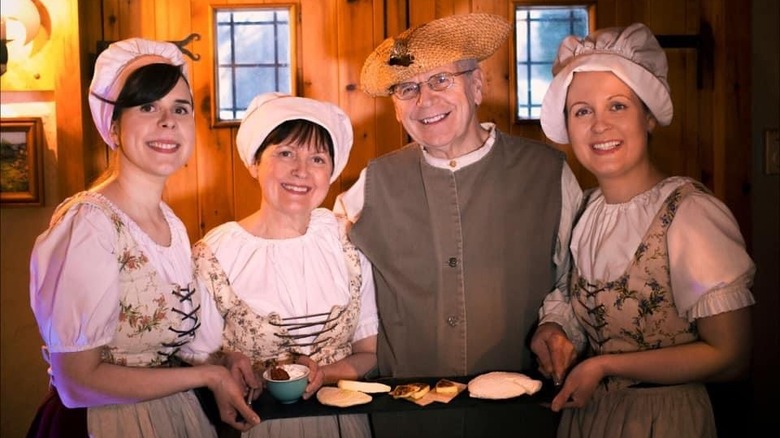 Family dressed in 1800s clothes with cheese