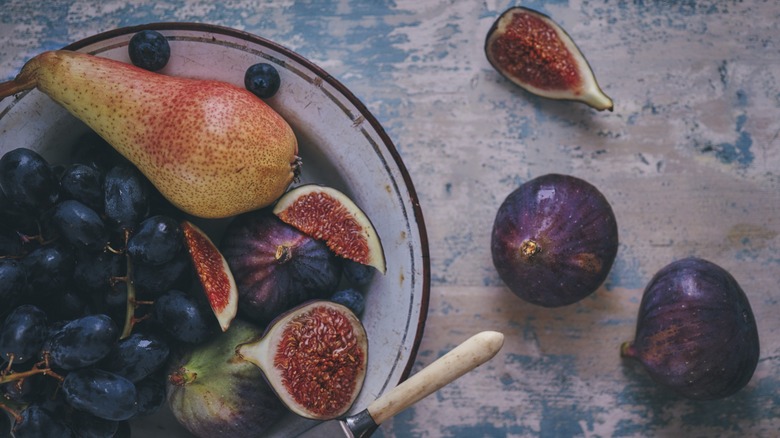 Top-down view of figs and grapes on a plate