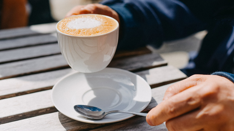 Person drinking a café au lait