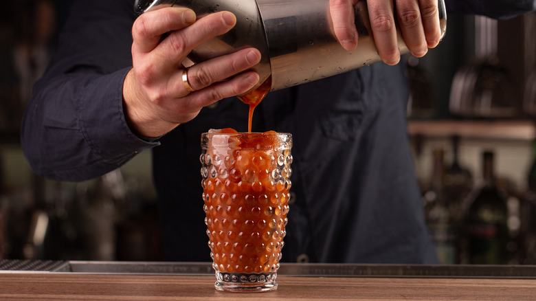 bartender pouring bloody mary cocktail