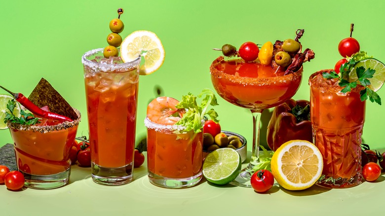 various bloody mary cocktails on green background