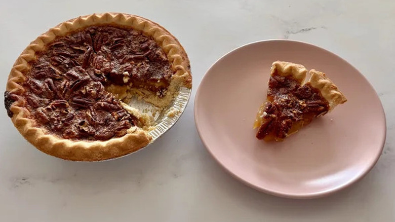 Walmart pecan pie next to a small slice on a pink plate