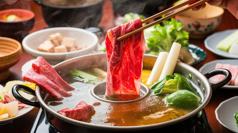 dipping meat into Chinese hot pot