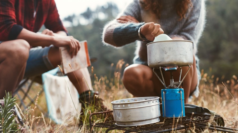 couple using camping stove outdoors