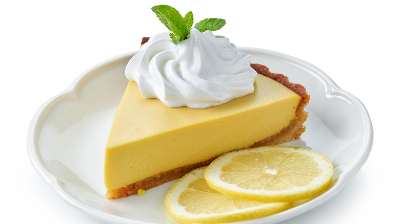 lemon pie garnished with mint and whipped cream on a plate