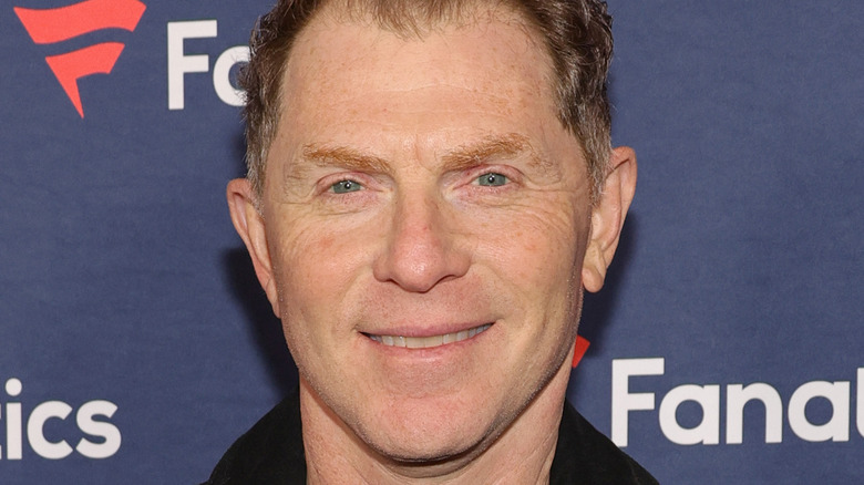 Bobby Flay smiles on a red carpet