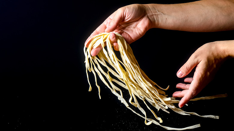 noodles tossed between hands