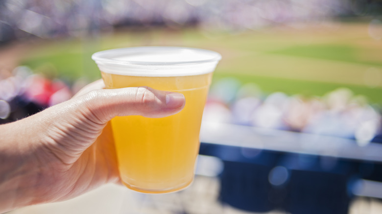 A person holding a plastic cup of beer