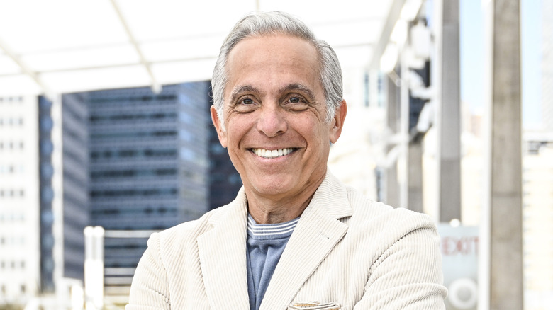 Geoffrey Zakarian smiling in white blazer