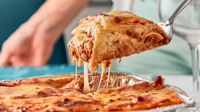 woman serving portion of lasagna 