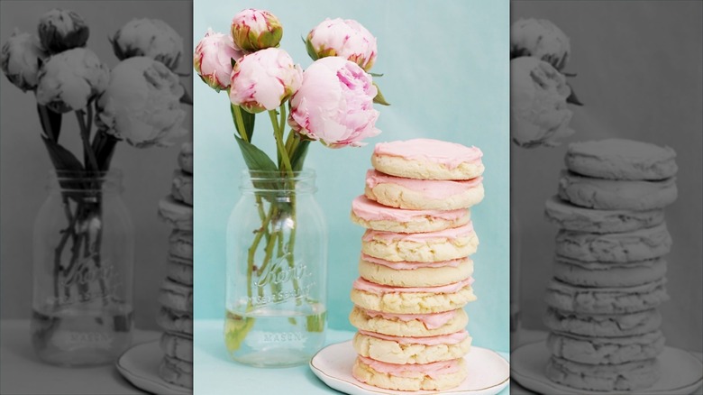 Dutchman's market  pink-frosted sugar cookies stacked next to pink flowers