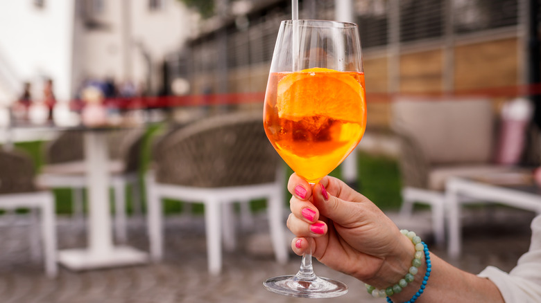 woman holding aperol spritz