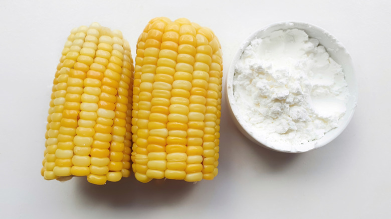 A bowl of cornstarch next to pieces of corn