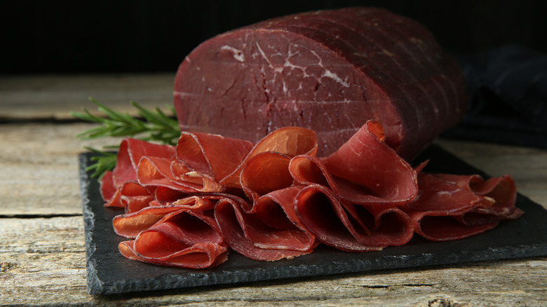 Sliced bresaola with fresh rosemary