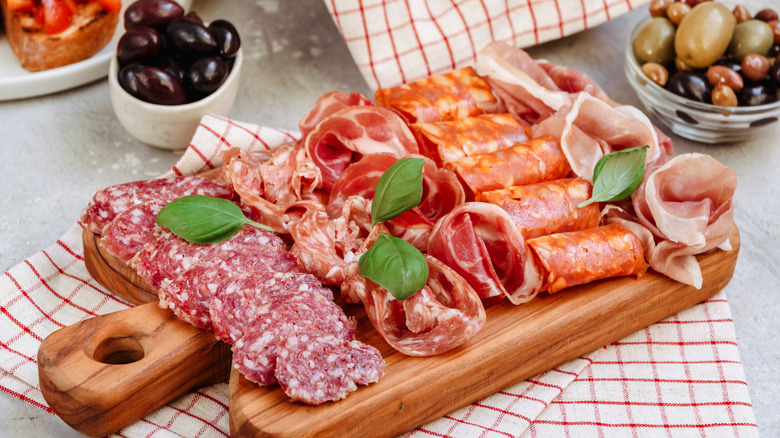 A charcuterie board with meat and olives