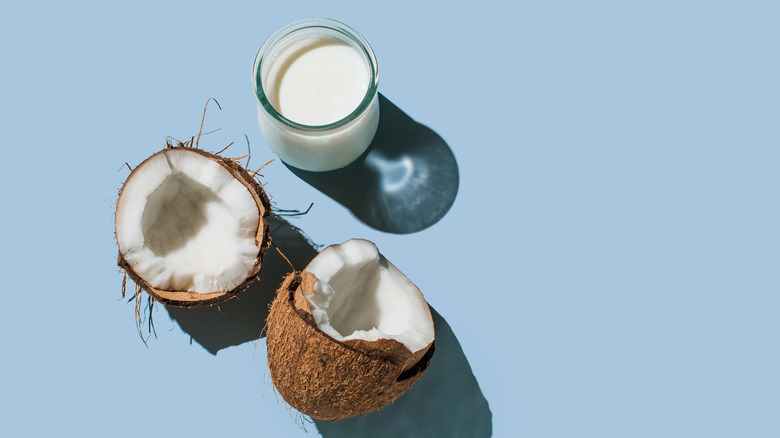 glass of coconut milk with cracked coconut