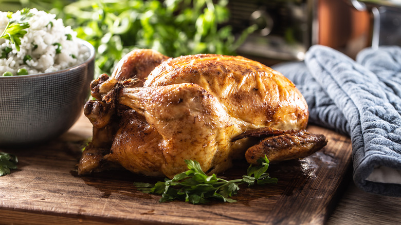 Whole roast chicken on cutting board