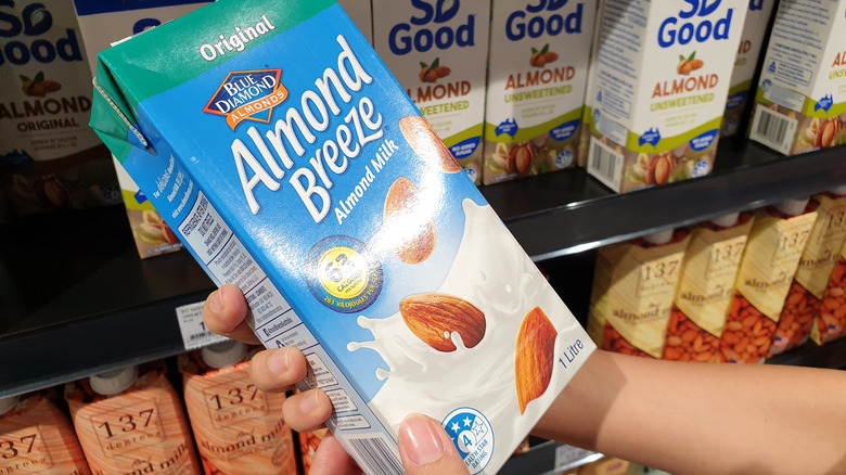 person holding carton of Almond Breeze almond milk