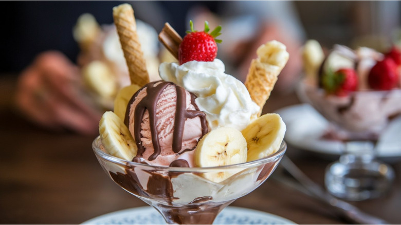 Ice cream sundaes on table with fruits as toppings