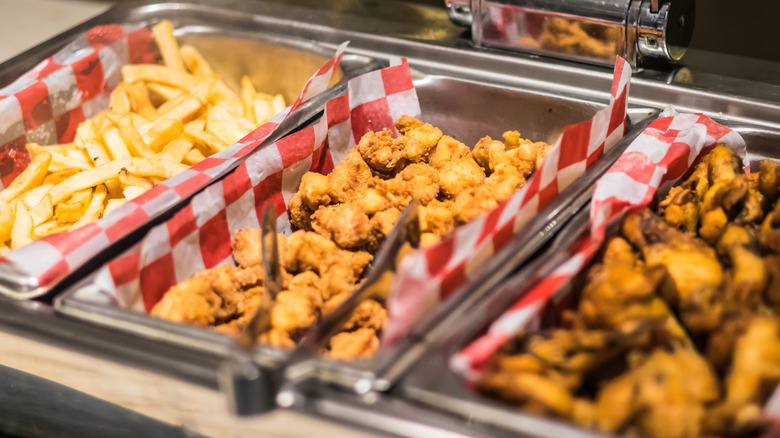 fried chicken and fries in buffet trays with tong