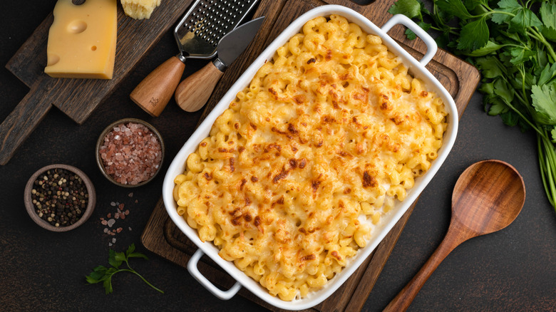 Aerial view of a large tray of mac and cheese with kitchen utensils and ingredients