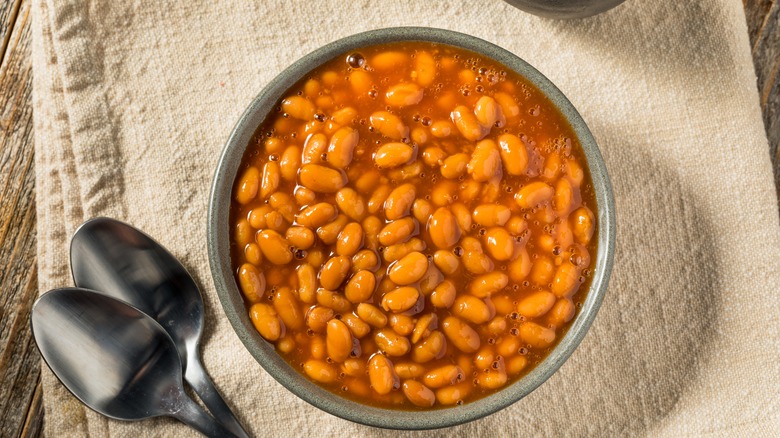 Baked beans in bowl with spoons