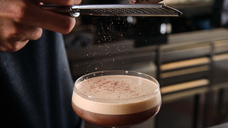 bartender shaving chocolate over martini