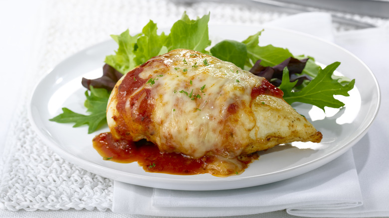 Plated chicken parmesan against a white background