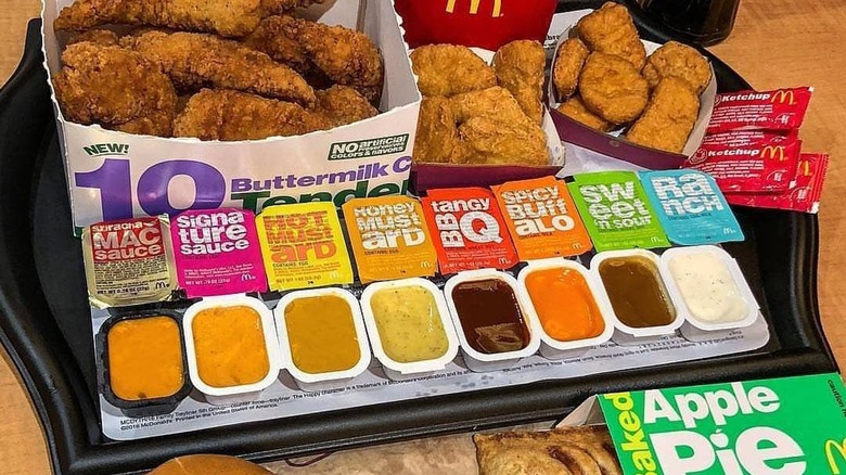 Row of opened McDonald's sauces in front of boxes of chicken