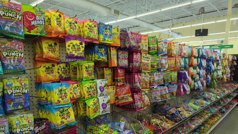 Candy aisle in a grocery store with sour candies in the foreground