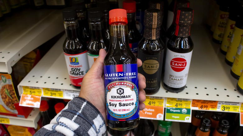 Hand holding up gluten-free Kikkoman soy sauce