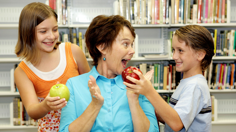 students giving teacher an apple