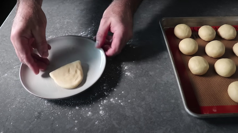 Person folding Parker House rolls