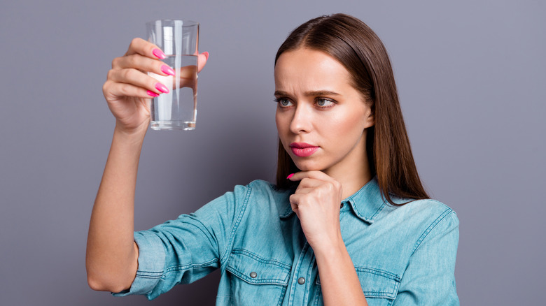 woman looks at water glass