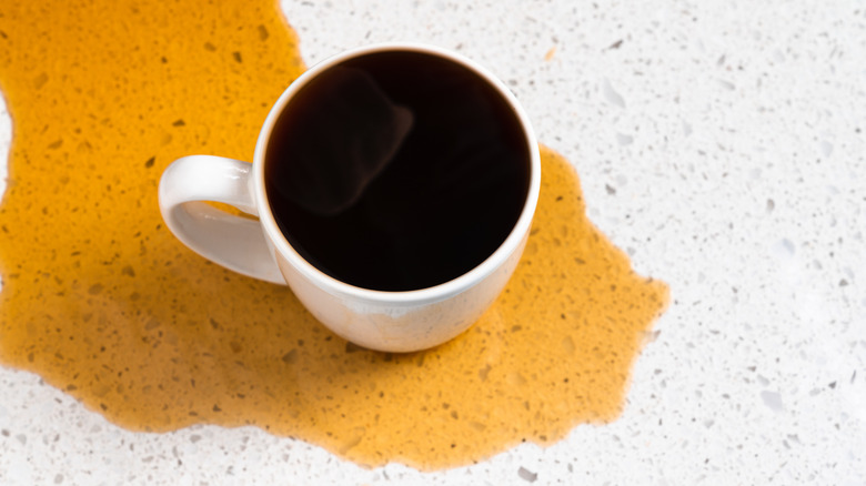 coffee overflowing from cup to countertop