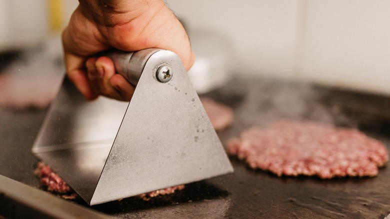 Cook smashing a patty 