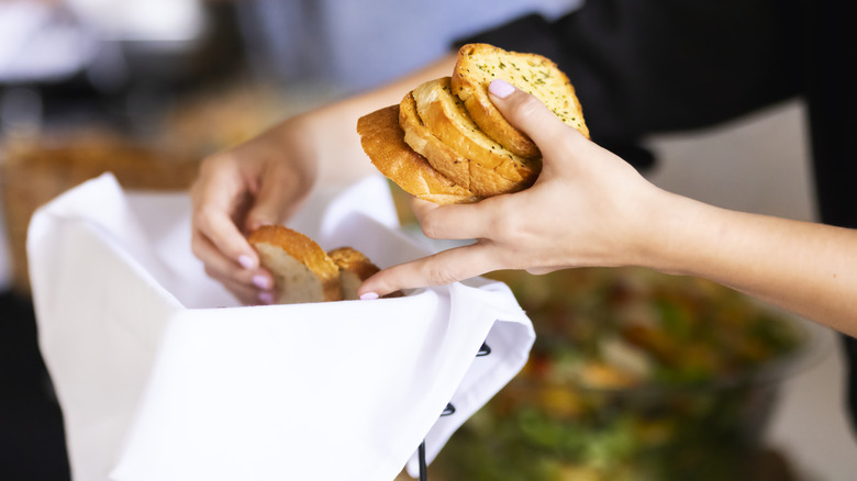 Server placing bread in a basket