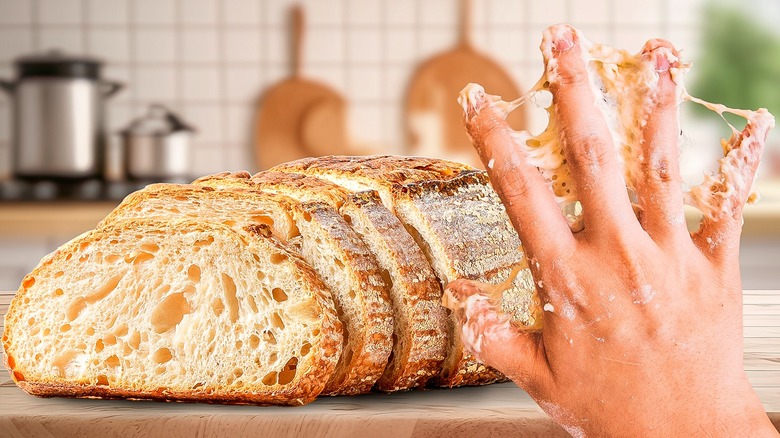 Hand with sticky dough and bread