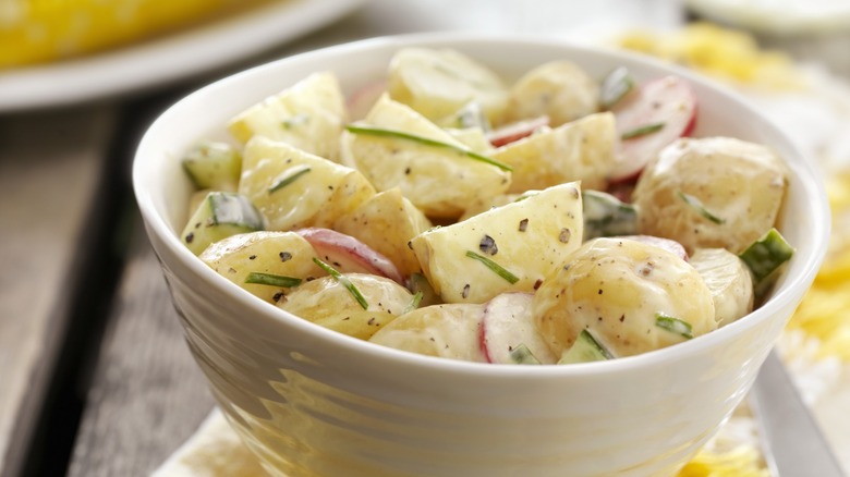 Creamy potato salad in white bowl