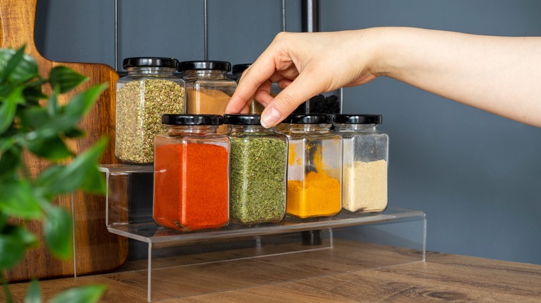 hand reaching for spice rack