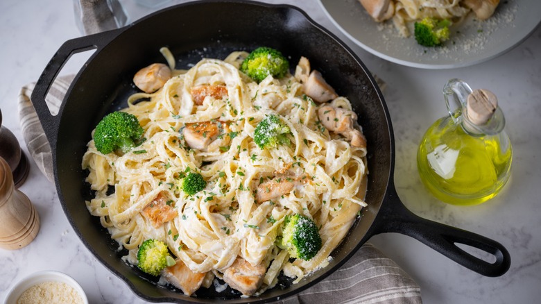 Pan of fettucine alfredo with oil jar