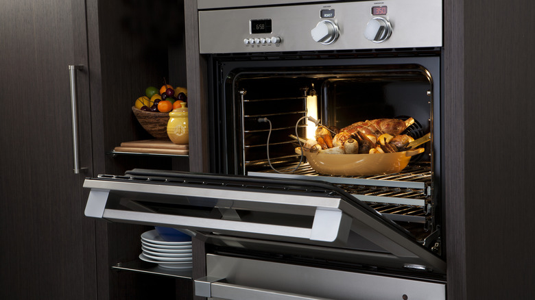 Open oven with food roasting