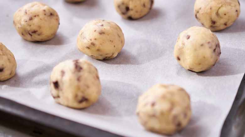 raw cookie dough balls on sheet pan