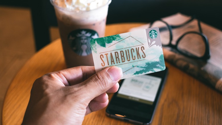 A Starbucks gift card in front of a Frappuccino