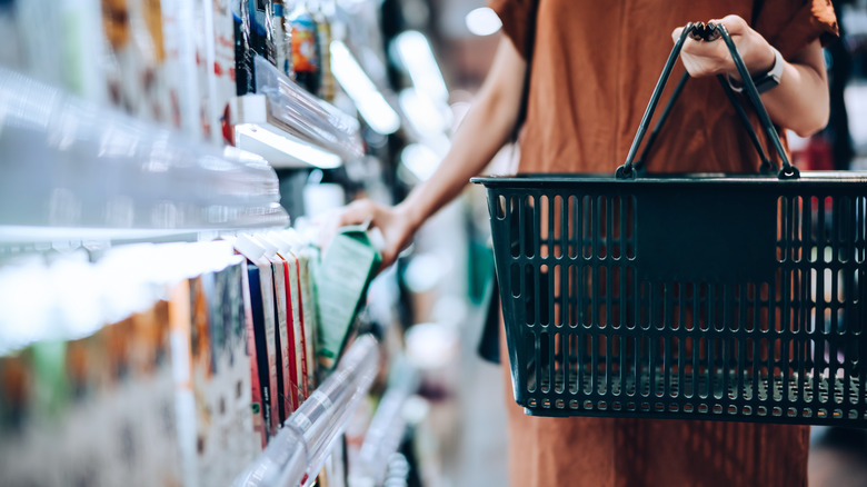 Shopper takes beverage from store shelf