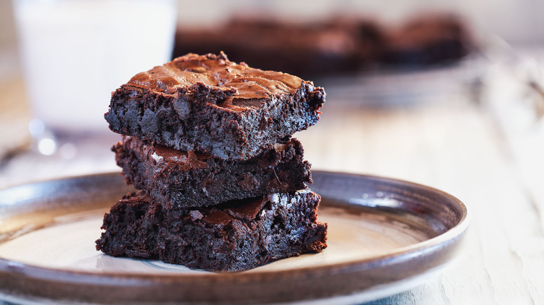 fresh fudgy brownies stacked on a plate