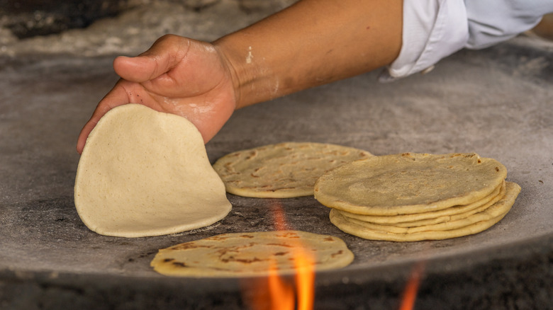person cooking tortillas